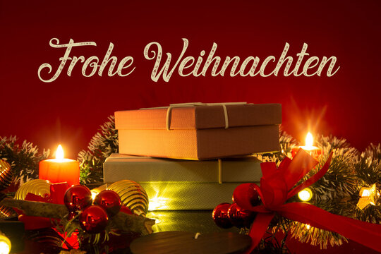Weihnachtsgrüße: Tisch mit Weihnachtsdekoration und Geschenken vor rotem Hintergrund mit eingefügtem Schriftzug FROHE WEIHNACHTEN