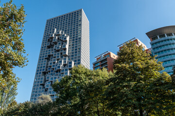 Fototapeta premium Moderner Wolkenkratzer mit markanter Fassadenstruktur neben Wohnbauten, Tirana, Albanien