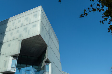 Obraz premium Modernes Glasgebäude mit markanter Fassade und blauem Himmel, Tirana, Albanien