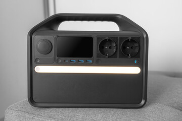 Modern portable power station with multiple charging ports and AC outlets sitting indoors, suitable for home backup or outdoor use.