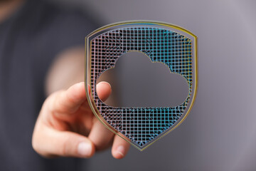 Abstract image of a hand holding a cloud shield, representing digital security, protection, and...