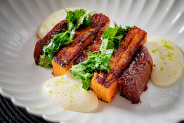 Tender blackened squash slices topped with fresh greens and creamy sauce create a vibrant dish