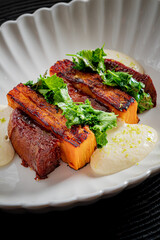 Grilled pumpkin slices with greens and creamy sauce offer an exquisite dining experience