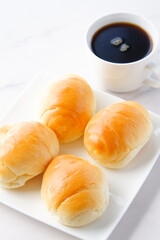 コーヒーとバターロール - 熱々のバターロールと、香りのよいコーヒーが用意された朝食のテーブル
