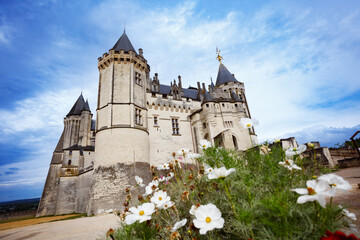 Majestic Saumur castle towers set against a vibrant blue sky