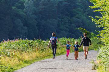 Four people enjoy peaceful nature walk in lush greenery, England