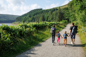 Parents and kids walking together along a scenic forest path