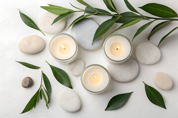Top view of white candles, spa stones, and green leaves on light background. Calm atmosphere for wellness, mindfulness, relaxation, and natural balance.