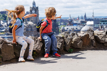 Excited kids with backpacks point out city of Edinburg, Scotland
