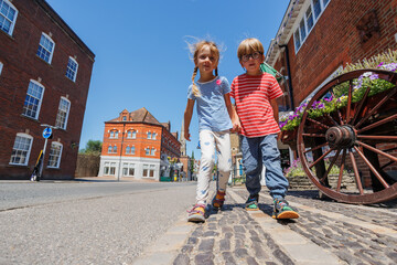 Two kids enjoy a walk in picturesque town setting, Farnham, UK