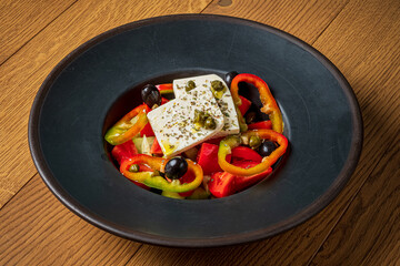 A colorful mix of peppers, olives, and feta cheese creates a delightful dish on a wooden surface