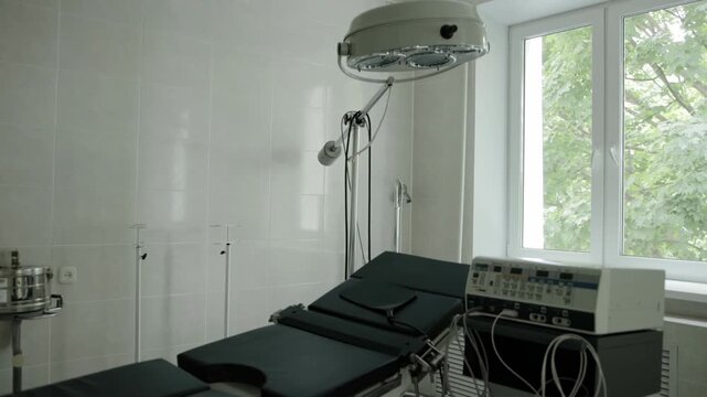 Surgical room in a clinic, interior. Couch and electrocoagulator in the room against the background of a window. Providing emergency health care, professionals