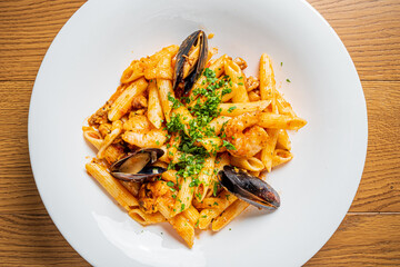 Penne pasta with shrimp, scallops, mussels, rich sauce, and fresh herbs