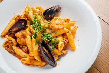 A vibrant bowl of seafood pasta with mussels and shrimp, garnished with parsley, awaits enjoyment