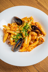 A delicious seafood pasta featuring penne, mussels, and herbs, beautifully presented on a plate
