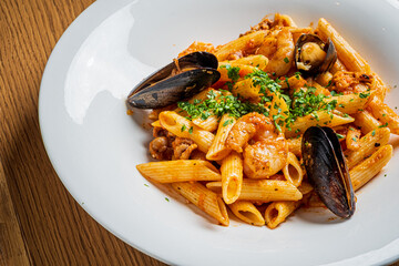 A colorful dish of seafood pasta featuring mussels and shrimp, garnished with herbs