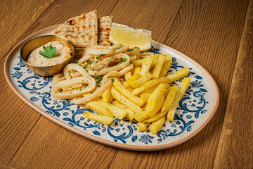 Tasty spread features golden fries, fluffy bread, and a creamy dip garnished with herbs