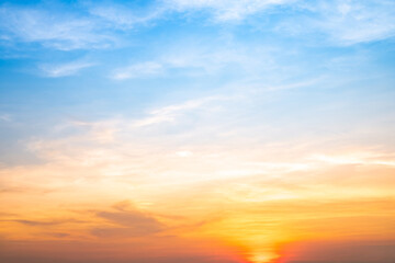 Sunset or sunrise sky with a vibrant gradient of orange, gold, and soft blue. Clear atmosphere with wispy clouds. Peaceful, natural light background. hope, freedom, new day and inspirational Concepts
