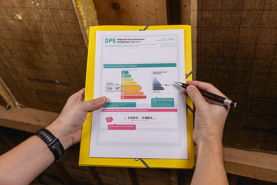 Une personne en train de remplir le formulaire du DPE pour l'immobilier dans un grenier.