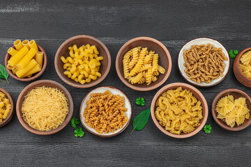 Pasta. Various kinds of uncooked pasta and noodles over wooden background. Traditional Italian