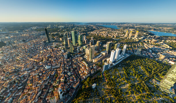 Istanbul, Turkey. Panoramic aerial drone view of European city skyline with skyscrapers, Bosphorus Strait and Zincirlikuyu Cemetery at sunset, clear sky. Aerial view