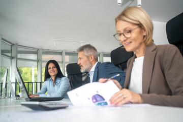Obraz premium Laptop, collaboration and business people in the office while working on a company project. Technology, teamwork and team doing corporate research in discussion together with technology in workplace