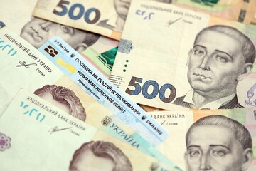 Ukrainian residence permit card or permanent resident card on Ukrainian money close up
