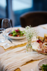 Fancy salad served on a white plate with champagne glass on the side in a restaurant background