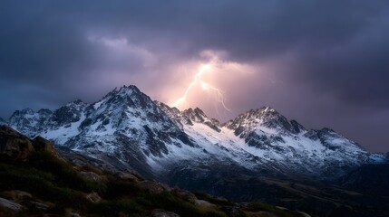 Dramatic lightning strikes over snow covered mountain peaks under a stormy sky