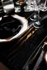 Luxurious setting of dark restaurant tables with candles and fresh flowers