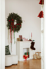 Fireplace decorated with a large green wreath, candles, and wrapped gifts. Traditional Christmas...