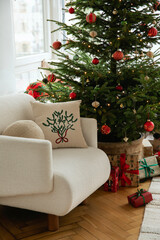 Living room with a Christmas tree, festive ornaments, and cozy armchair. Warm and inviting holiday mood.
