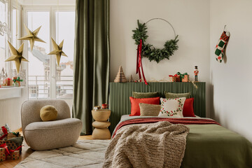 Stylish bedroom with beige armchair and decorations. Cozy atmosp