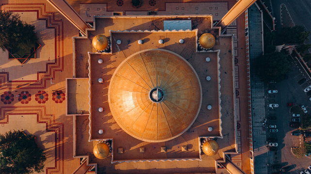 Aerial view of the National Mosque's golden dome reflecting the soft light, surrounded by geometrically patterned grounds, Abuja, Federal Capital Territory, Nigeria.