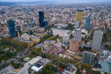 Obraz premium Aerial view of Tirana city center, Albania, featuring Skanderbeg Square, modern buildings, and autumn colors under soft daylight.