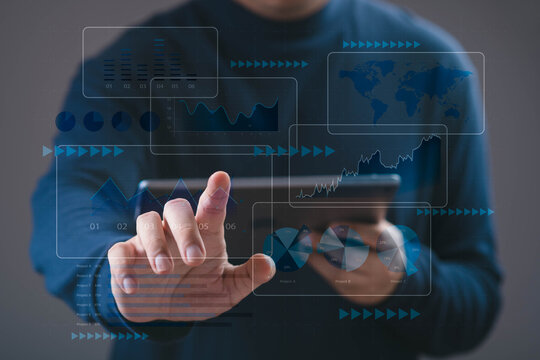 Businessman using a digital tablet with virtual data analytics charts, financial graphs, and global statistics, representing big data analysis, business intelligence, financial technology innovation.