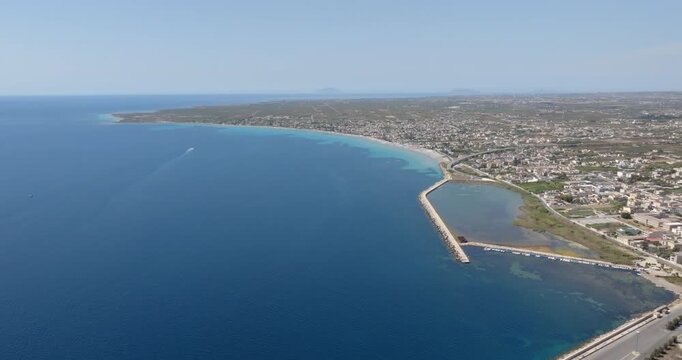 Panorama of the Sicilian coast near Mazara del Vallo, Italy. The coast faces the calm and blue Mediterranean Sea. The Aegadian Islands are in the background.