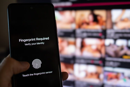 Hand using smartphone for identity verification and adult content access