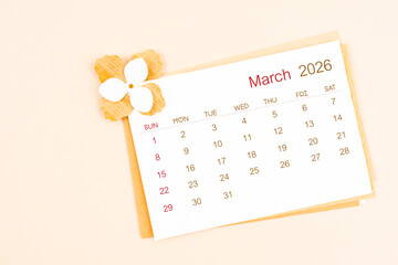 March 2026 calendar with origami flower paper on beige color background.