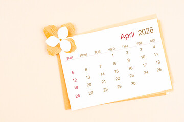 April 2026 calendar with origami flower paper on beige color background.