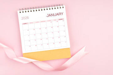January 2026 desk calendar with pink pastel ribbon.