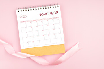 November 2026 desk calendar with pink pastel ribbon.