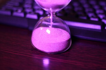 hourglass with the sand and computer keyboard time and work
