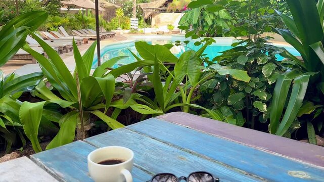 Close Up of Sunglasses and Coffee Cup on Wooden Bench in Tropical Resort Morning Paje Zanzibar Tanzania