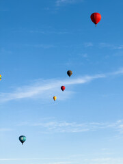 A hot air balloon flies over the city Yerevan, background of the blue sky. Aerial view of many colorful hot air balloons fly in the sky. High quality