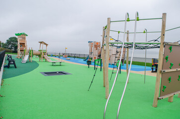 Fototapeta premium Empty childrens playground with wooden boat, slides and climbing frames