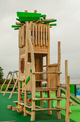 Empty childrens playground with wooden boat, slides and climbing frames