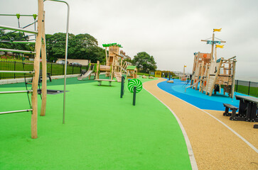 Empty childrens playground with wooden boat, slides and climbing frames