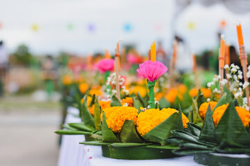 Colorful Loy Krathong floats with flowers, candles, and incense.