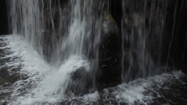 A river waterfall and stone architecture in a city park in spring